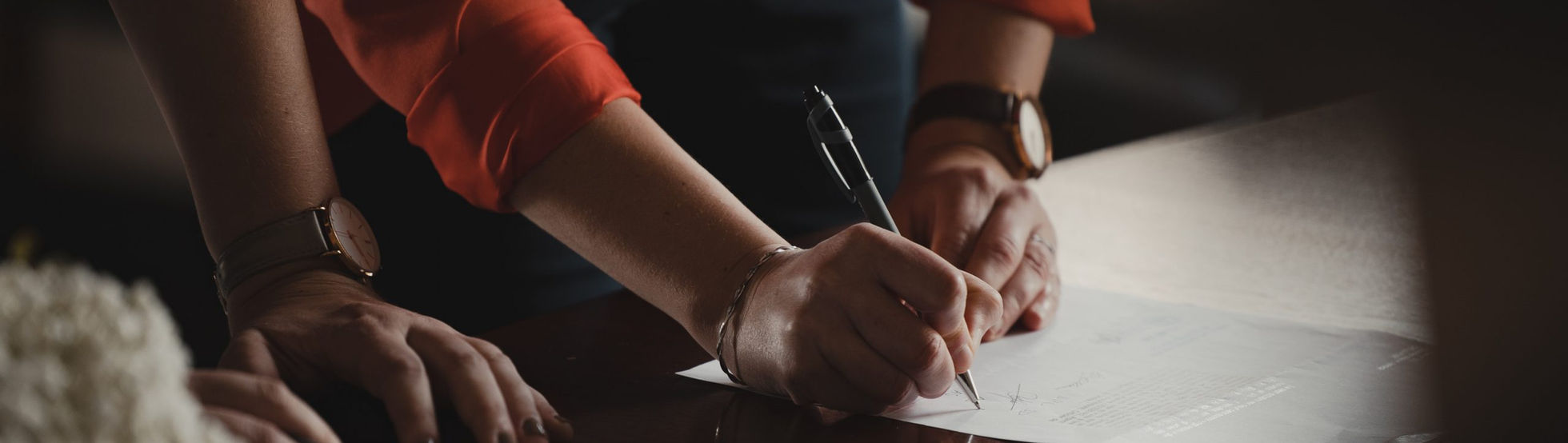 Client signing legal documents at a desk