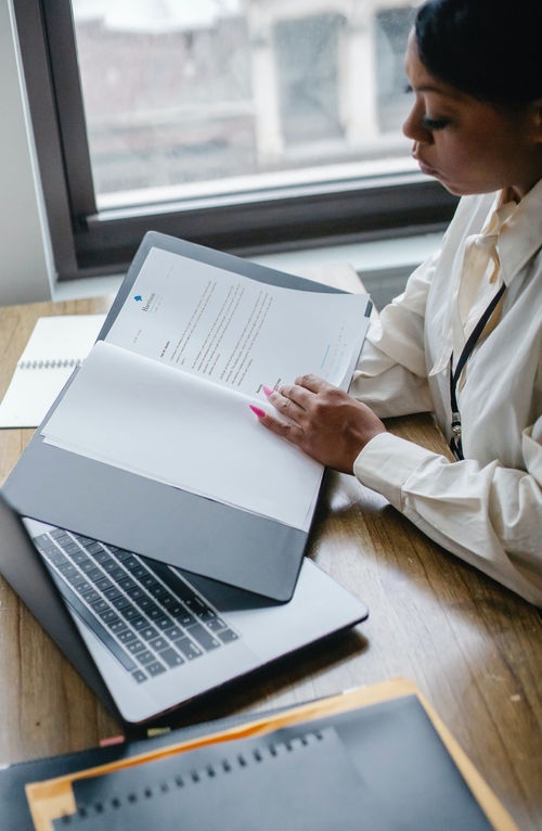 Solicitor reviewing documents at a desk with a laptop